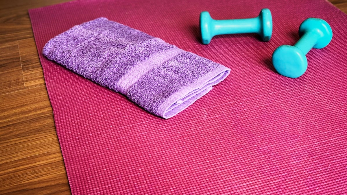 Yoga mat, weights, and a towel ready for a workout.